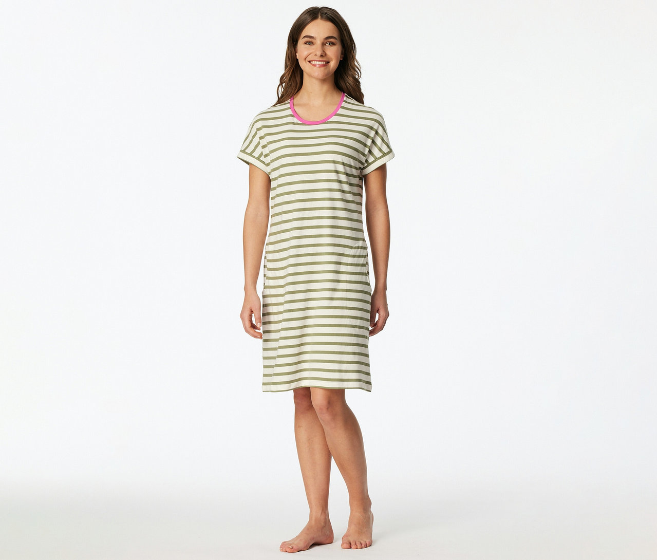 Eine lächelnde Frau steht barfuß und trägt ein SCHIESSER Nachthemd mit olivgrünen und cremefarbenen Querstreifen und pinkem Halsausschnitt.