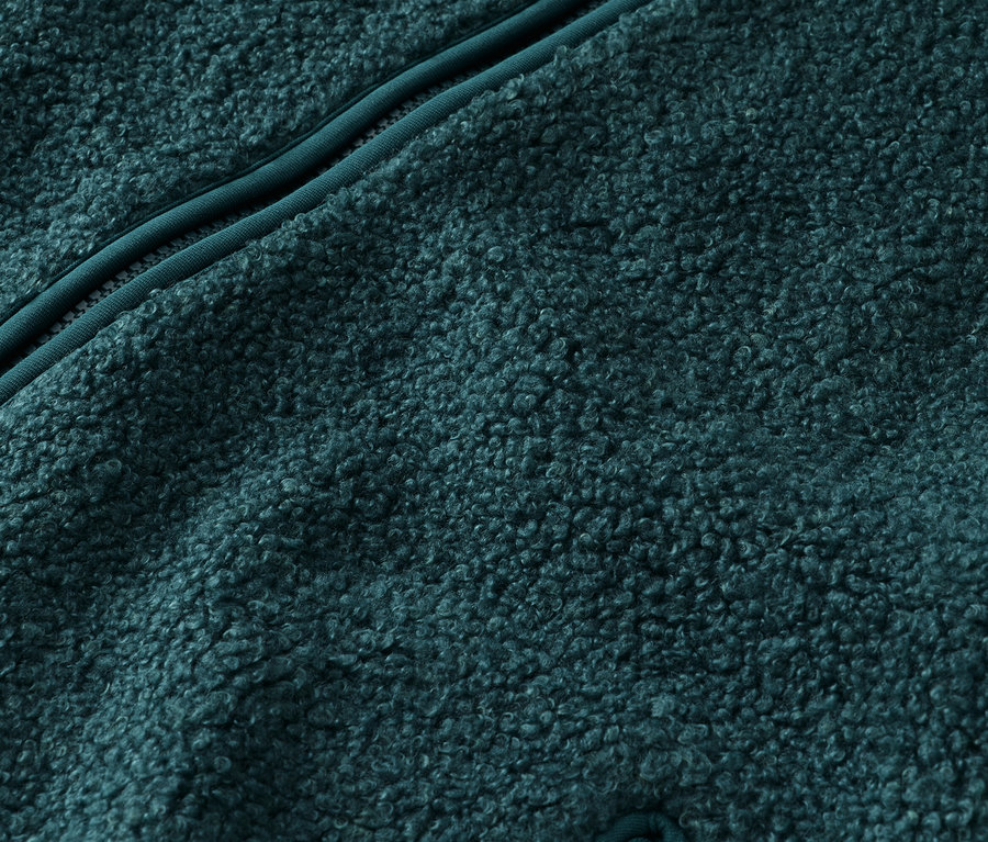 Nahaufnahme eines türkisfarbenen Fleece-Stoffes mit einem türkisfarbenen Reißverschluss.