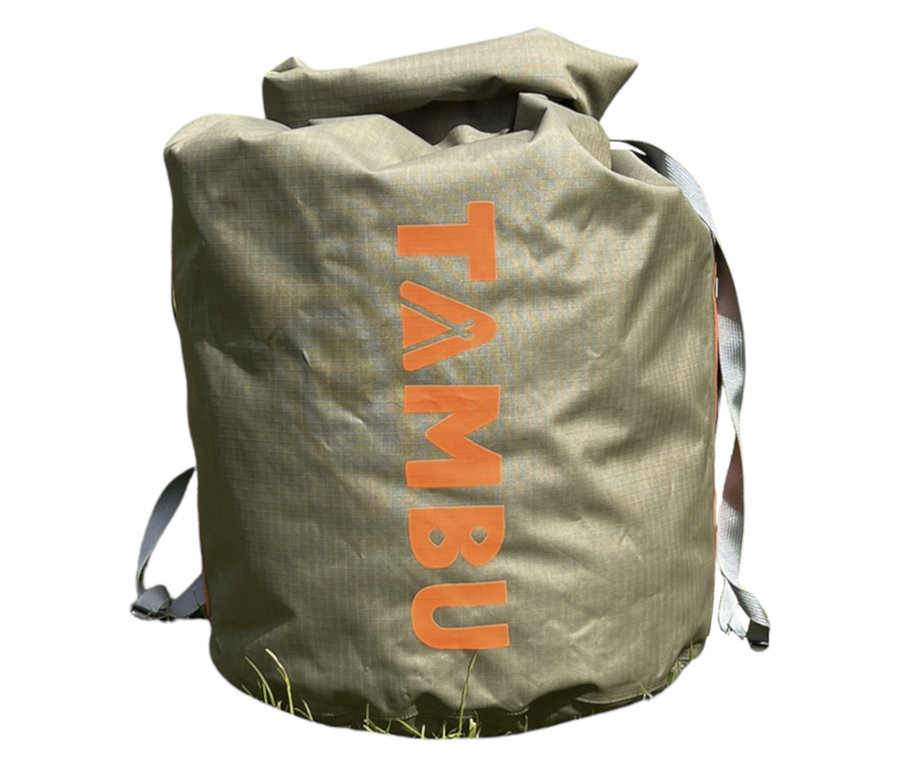 Der Tambu Wasserdichter Packsack »JOLA 80« in Khaki steht auf Gras und hat orangefarbene Schriftzüge und graue Träger.