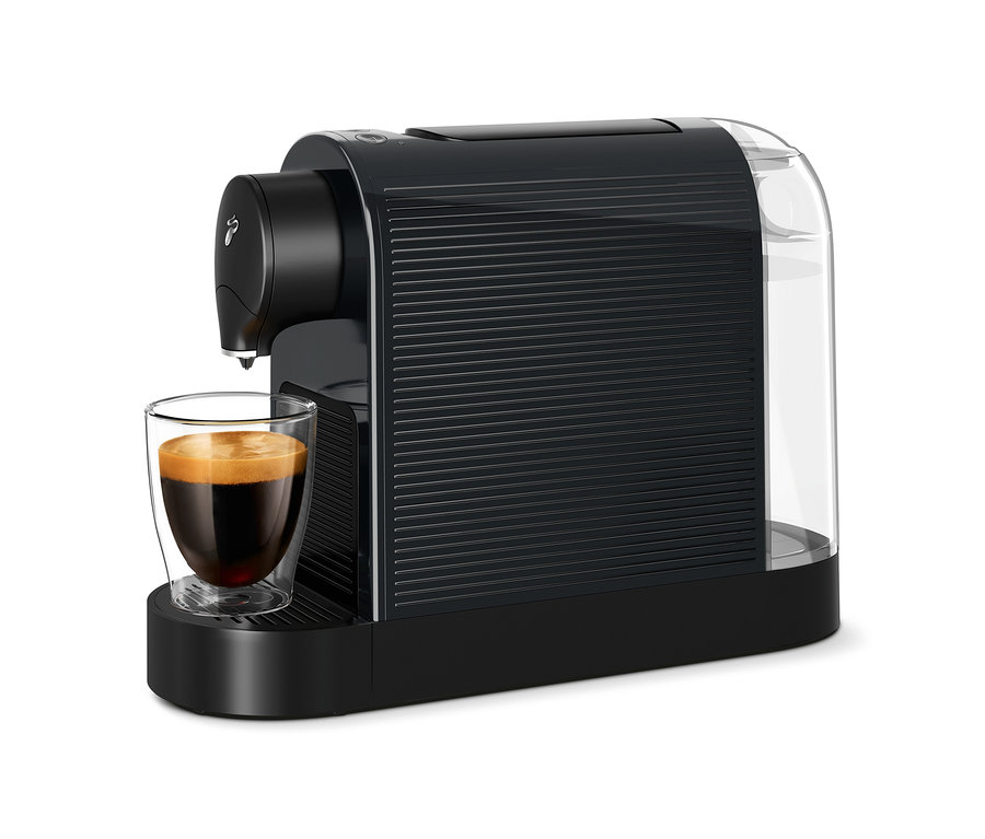 Kaffee fließt aus einer schwarzen Cafissimo pure+ Kaffeemaschine in ein Glas.
