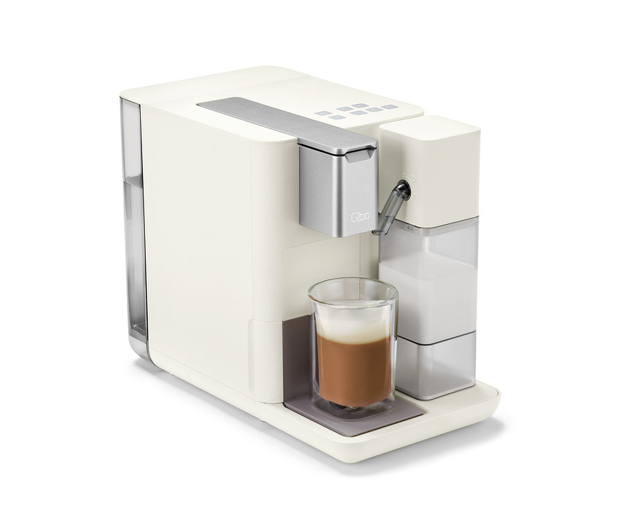 Qbo MILK MASTER White Cashmere Kaffeemaschine mit aufgeschäumtem Getränk in einer Tasse.