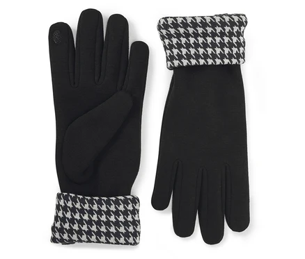 Ein Paar schwarze Handschuhe mit umgeschlagenen Stulpen im schwarz-weißen Hahnentrittmuster. Ein Handschuh liegt mit der Handfläche nach oben, der andere mit der Handfläche nach unten.
