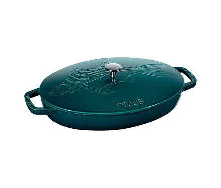 Ovaler, teal-farbener Bräter mit einem Deckel, der ein geprägtes Fischmotiv und einen silbernen Knauf zeigt. „STAUB“ ist auf dem Deckel sichtbar.