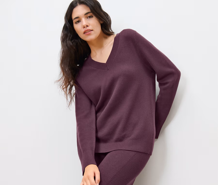 Frau posiert in Strickpullover.