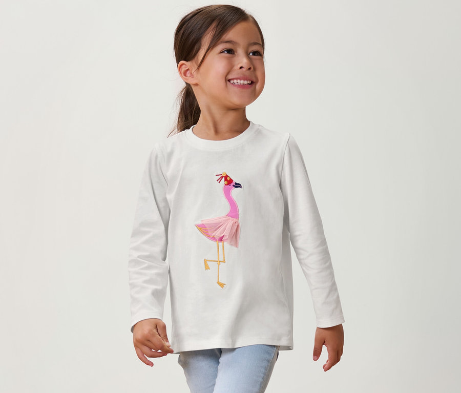 Lächelndes Mädchen trägt ein Kinder-Langarmshirt mit Flamingo.