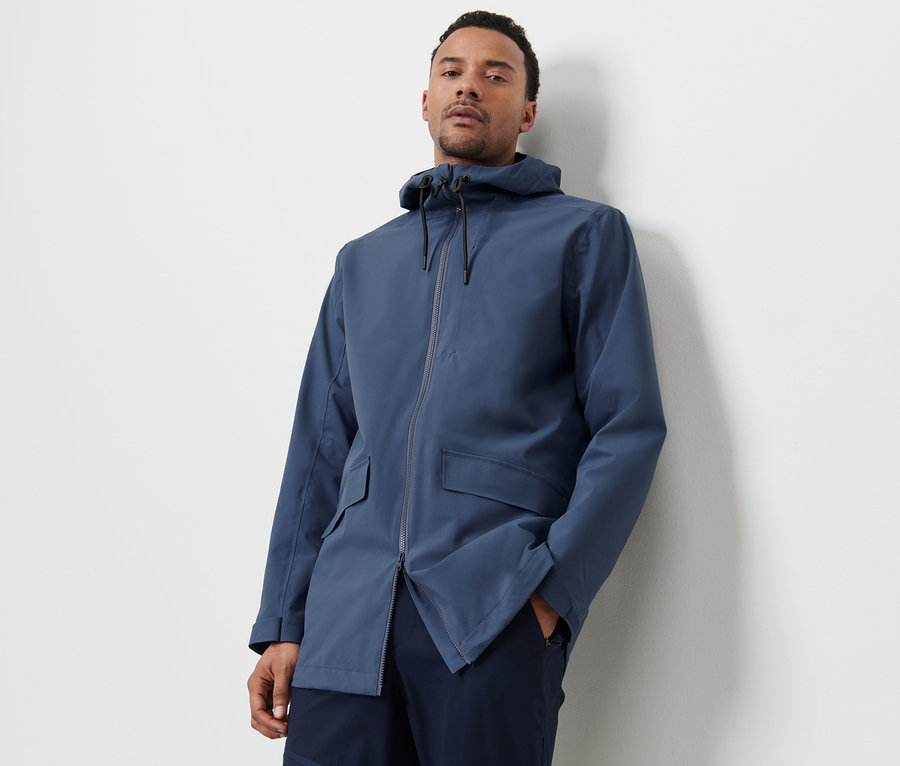 Mann posiert in blauer Outdoorjacke.