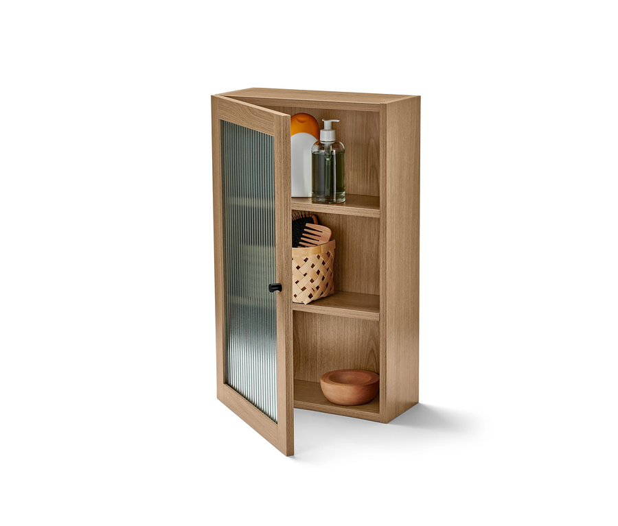 Offener Wandschrank mit Riffelglastür und verstauten Produkten.