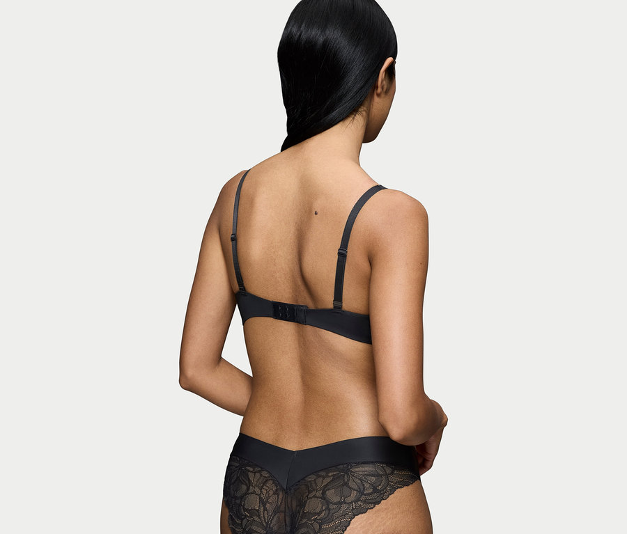 Rückansicht einer Frau mit schwarzem BH und Spitzenunterhose.