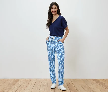 Frau posiert in blau bedruckter Jerseyhose.