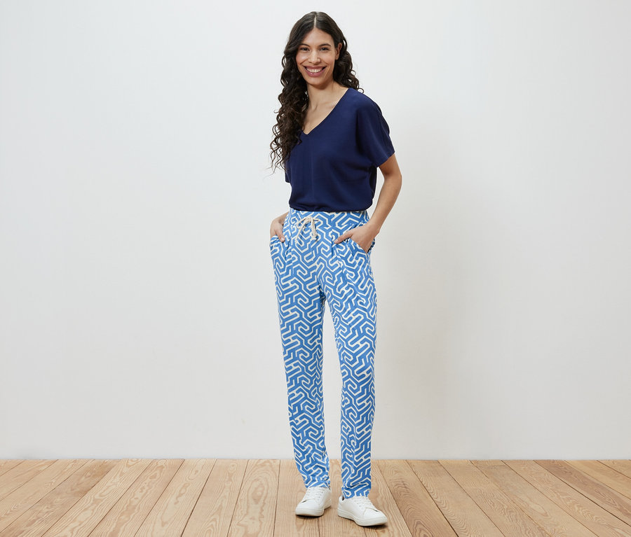 Frau posiert in blau bedruckter Jerseyhose.