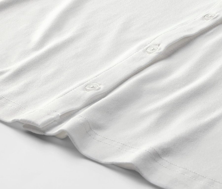 Detailansicht eines weißen Blusenshirts mit Knopfleiste.