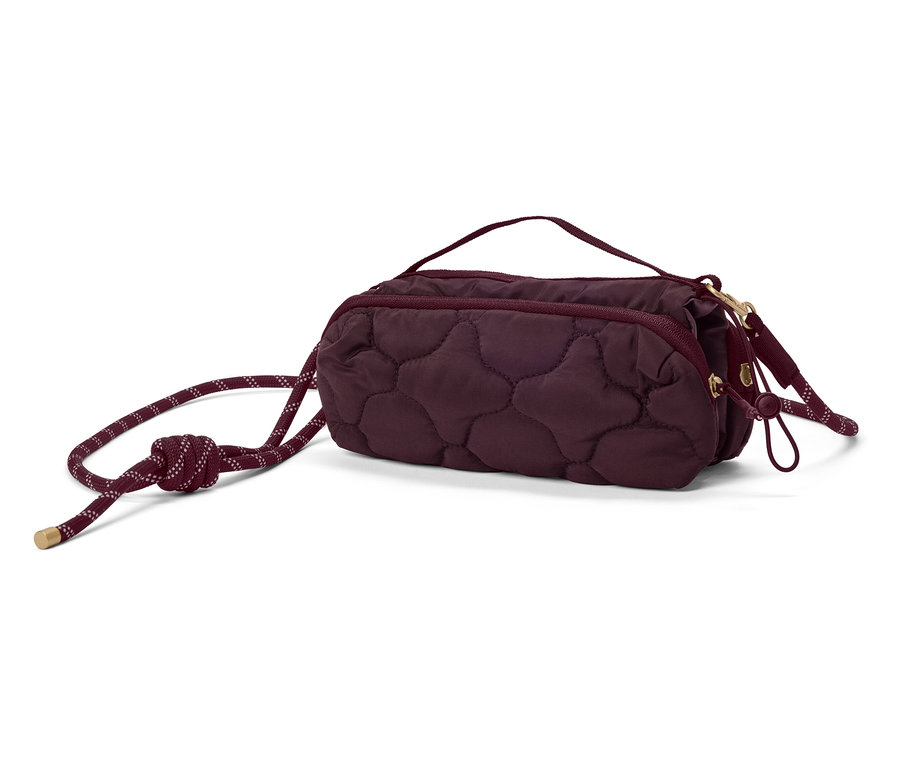 Nahaufnahme einer gesteppten, kastanienbraunen Handtasche mit Kordelzug.