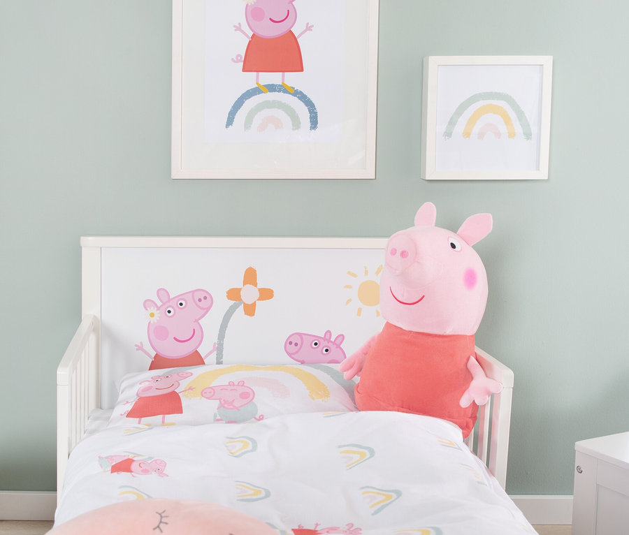 Ein Kinderzimmer mit einem Bett, das mit Peppa Wutz-Bettwäsche bezogen ist, einem Peppa Wutz-Plüschtier und zwei gerahmten Bildern an der Wand.