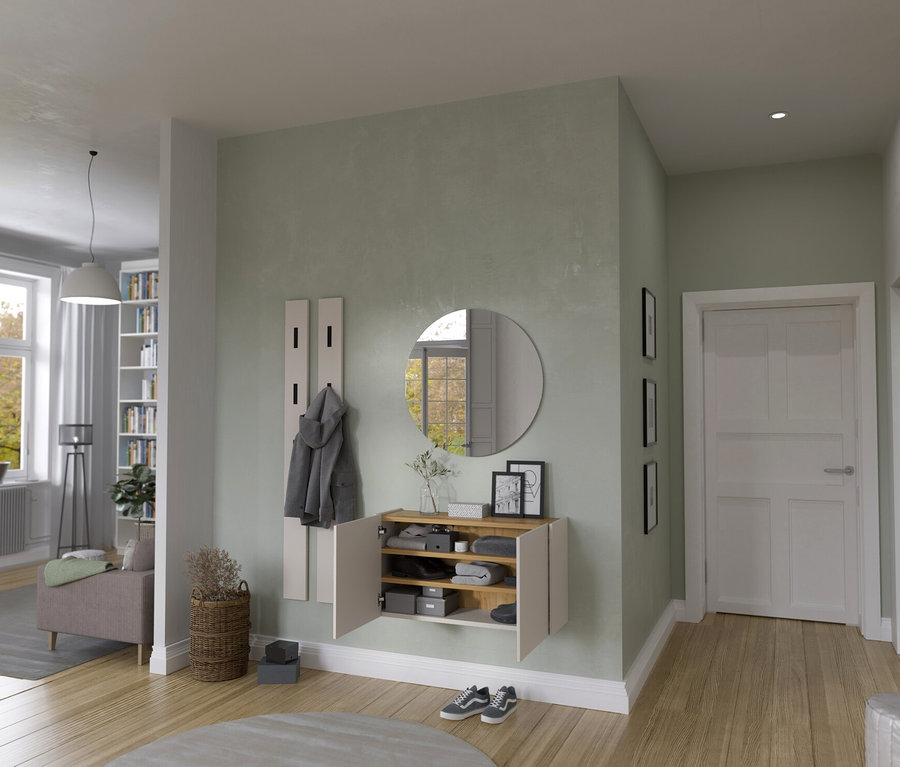 Flur mit Garderobe, Spiegel und Schuhschrank an mintgrüner Wand. Im Hintergrund Wohnzimmer mit Fenster und Couch.