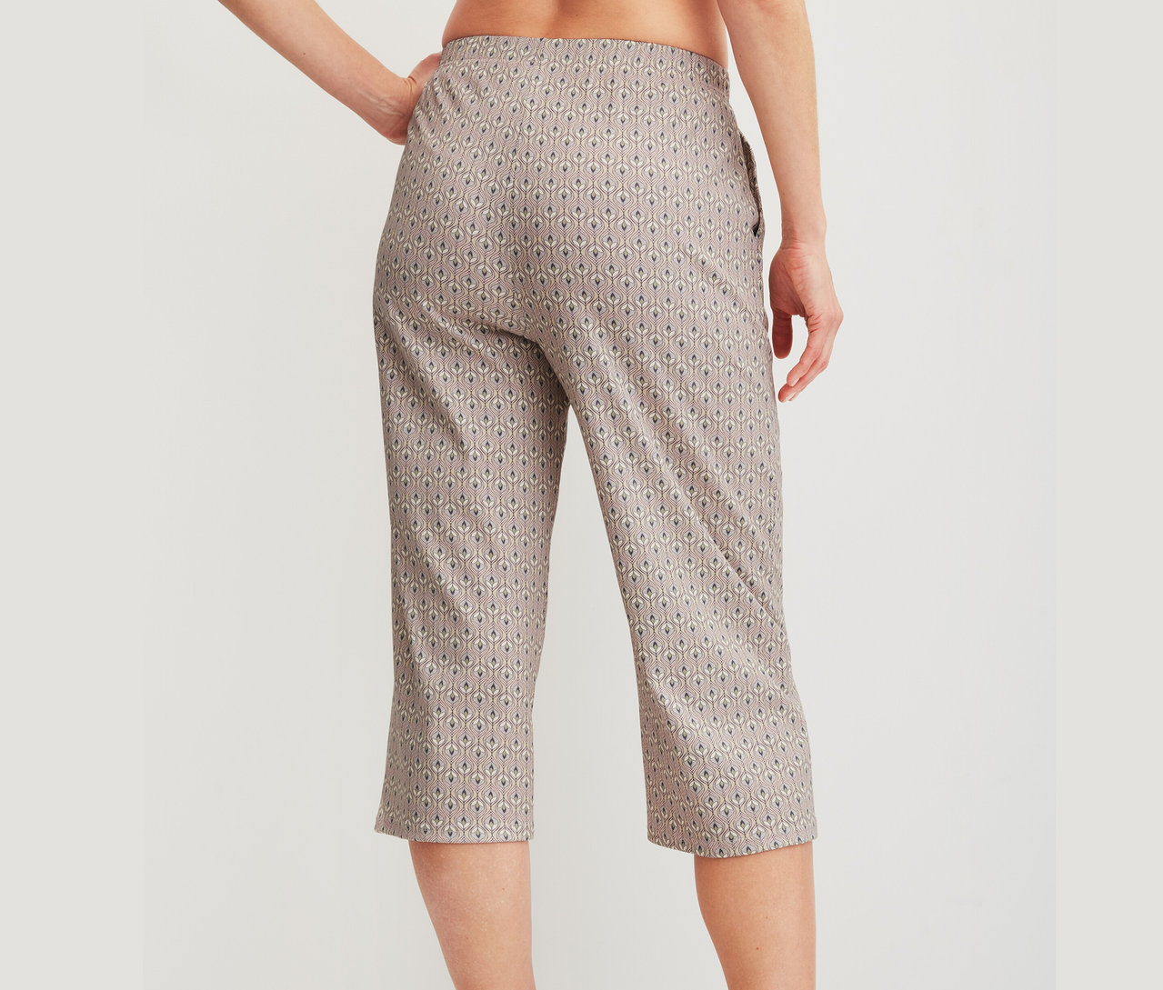 Frau trägt gemusterte Hose in Caprilänge.