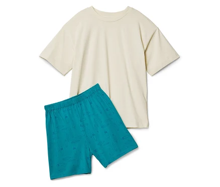 Ein cremefarbenes T-Shirt liegt neben türkisfarbenen Shorts mit Surfbrettmuster.