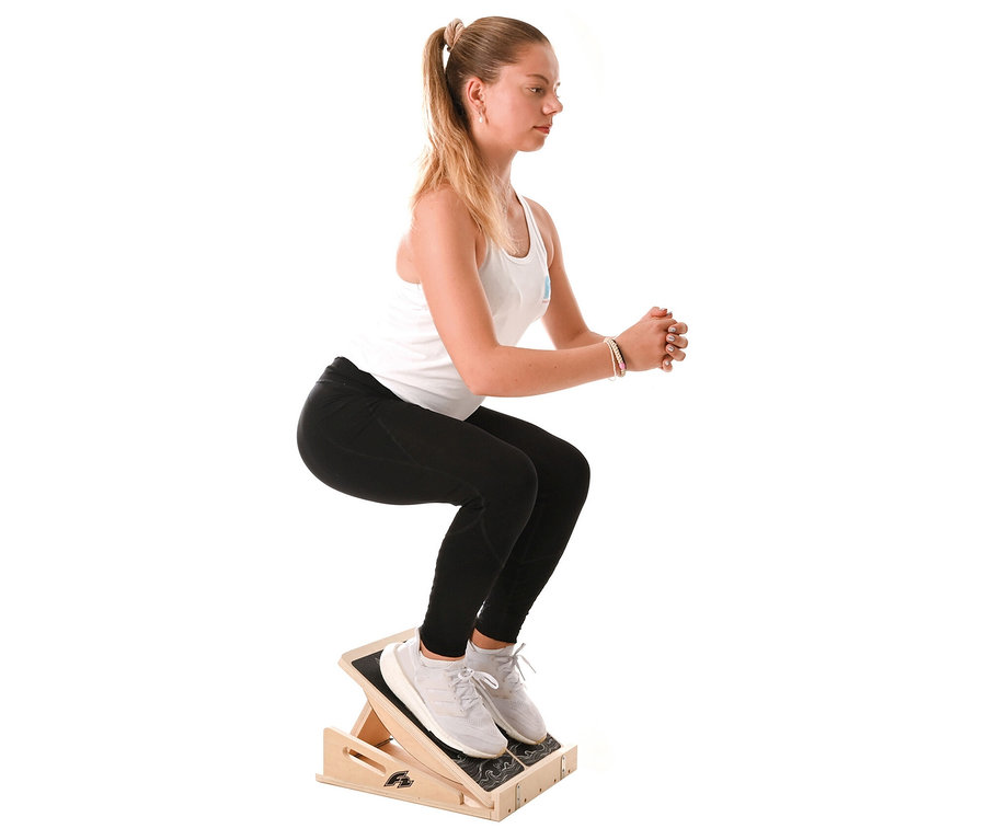 Frau macht Kniebeugen auf einem F2 Step on Balance Board.