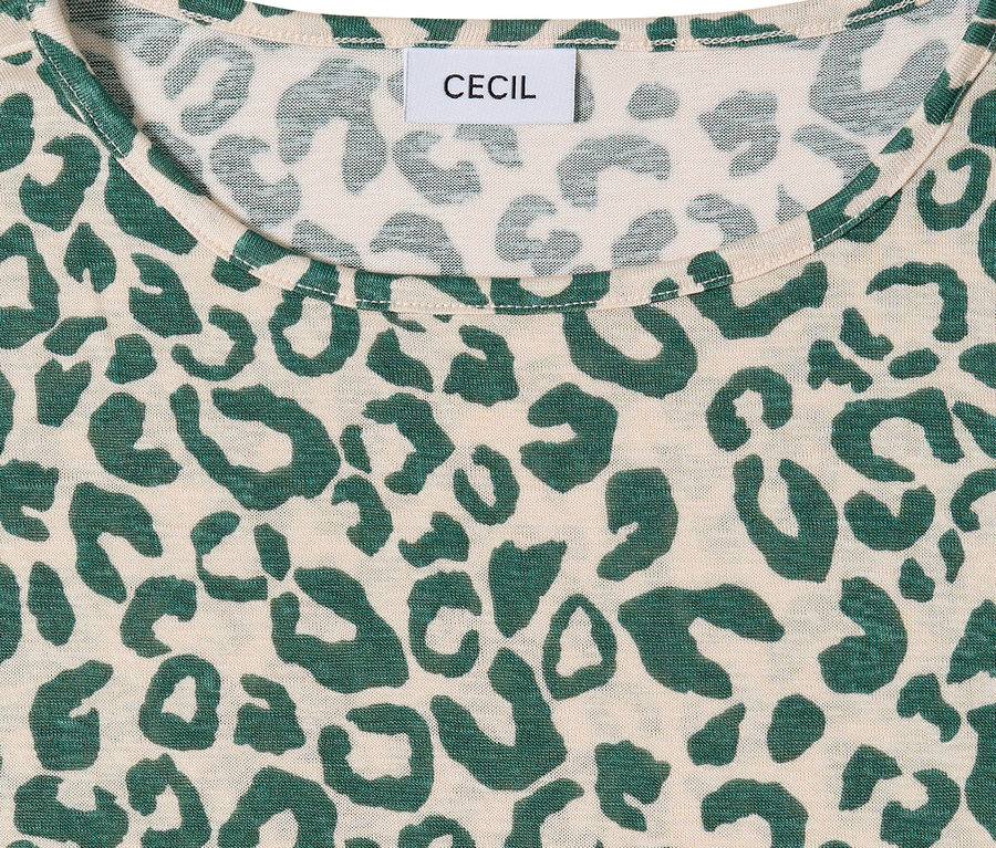 Nahaufnahme eines beigen CECIL Kurzarmshirts mit grünem Leopardenmuster. Das CECIL-Markenetikett ist am Halsausschnitt sichtbar.