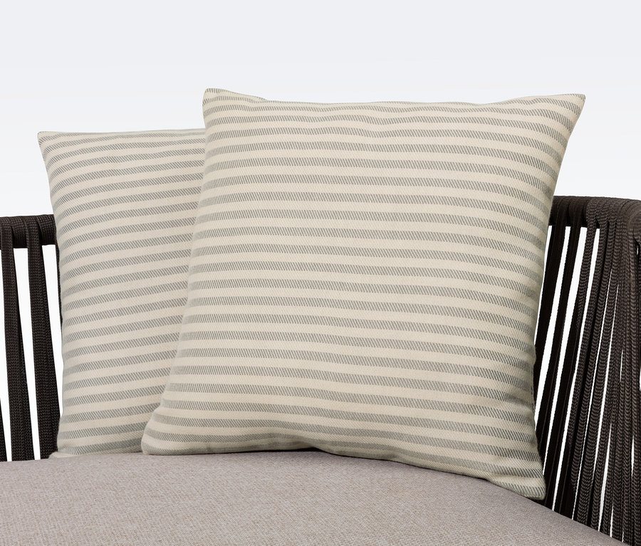 Zwei gestreifte Outdoor-Kissen in Leinen-Haptik liegen auf einem Sitzmöbel.