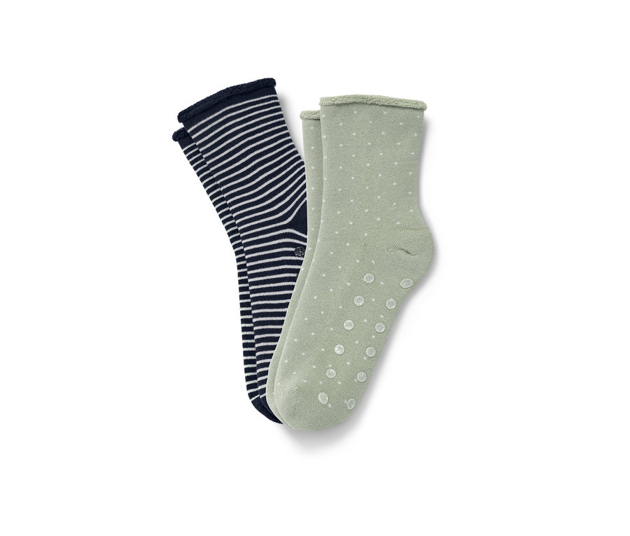 Zwei Paar Hygge-Socken: ein Paar ist dunkelblau mit weißen Streifen, das andere hellgrün mit weißen Punkten.