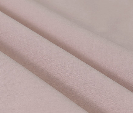 Nahaufnahme von Falten der rosafarbenen Perkal-Bettwäsche in Normalgröße und Übergröße.