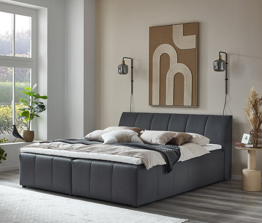 Schlafzimmer mit grauem DOMO collection Boxspringbett 180 x 200 cm inklusive Topper.