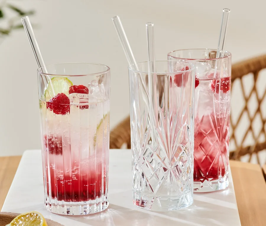 Drei Gläser mit Getränken und 4 Glas-Trinkhalme.