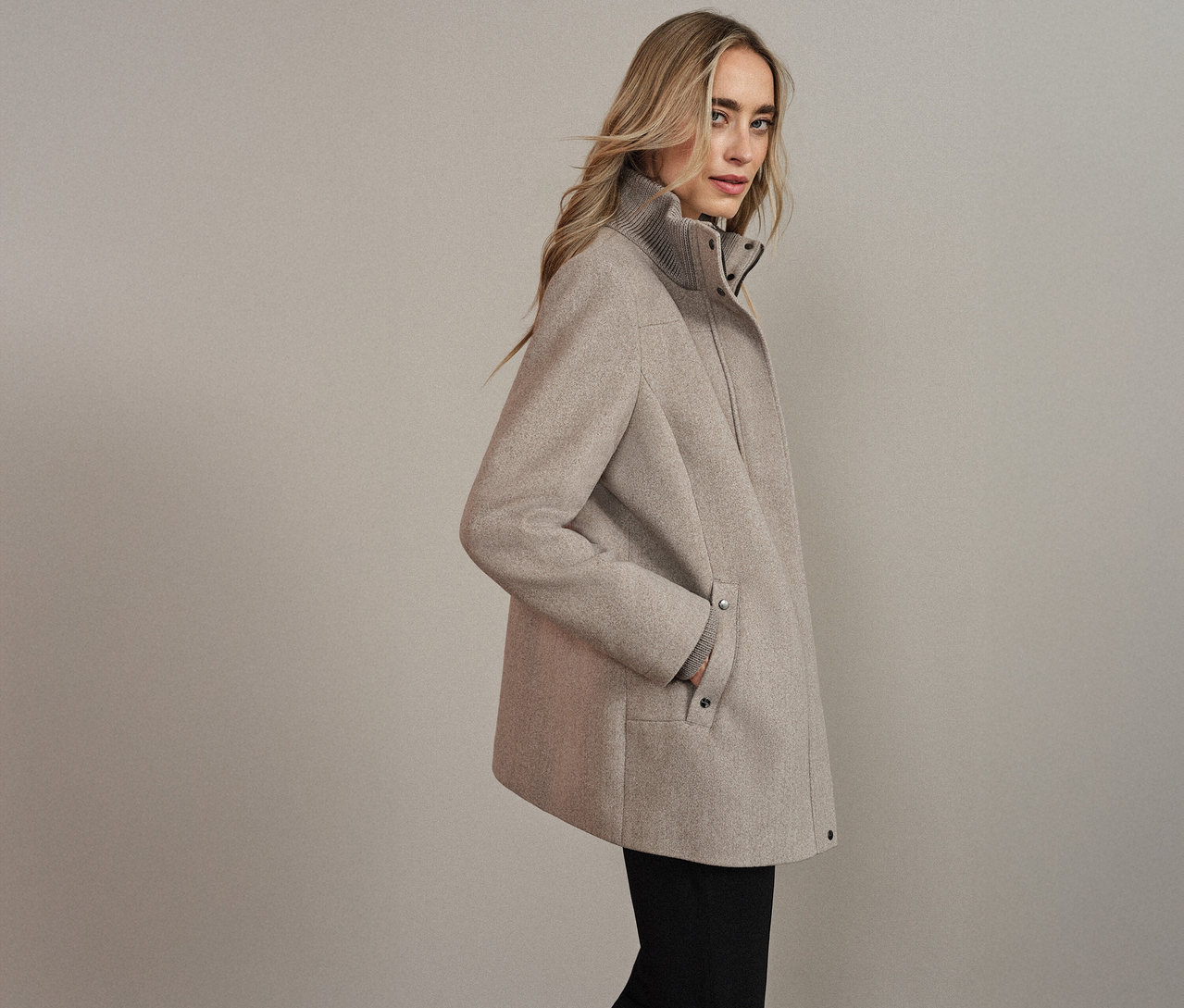 Frau mit einem Street One Kurzmantel in Beige, die Hand in der Tasche.