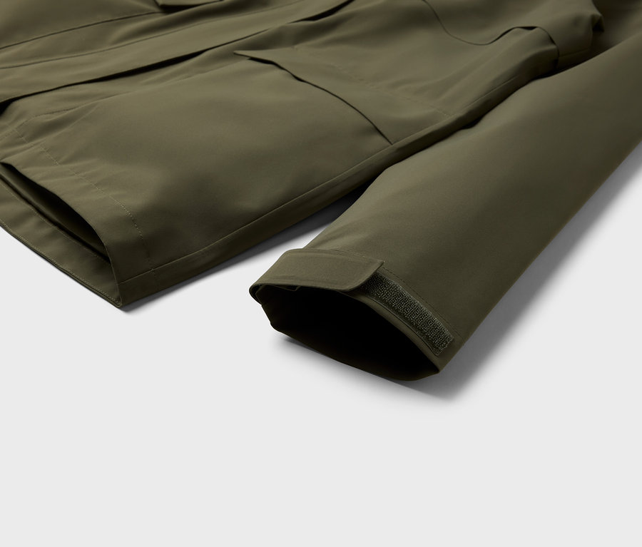 Detailaufnahme einer olivgrünen Jacke mit Taschen und Ärmel.