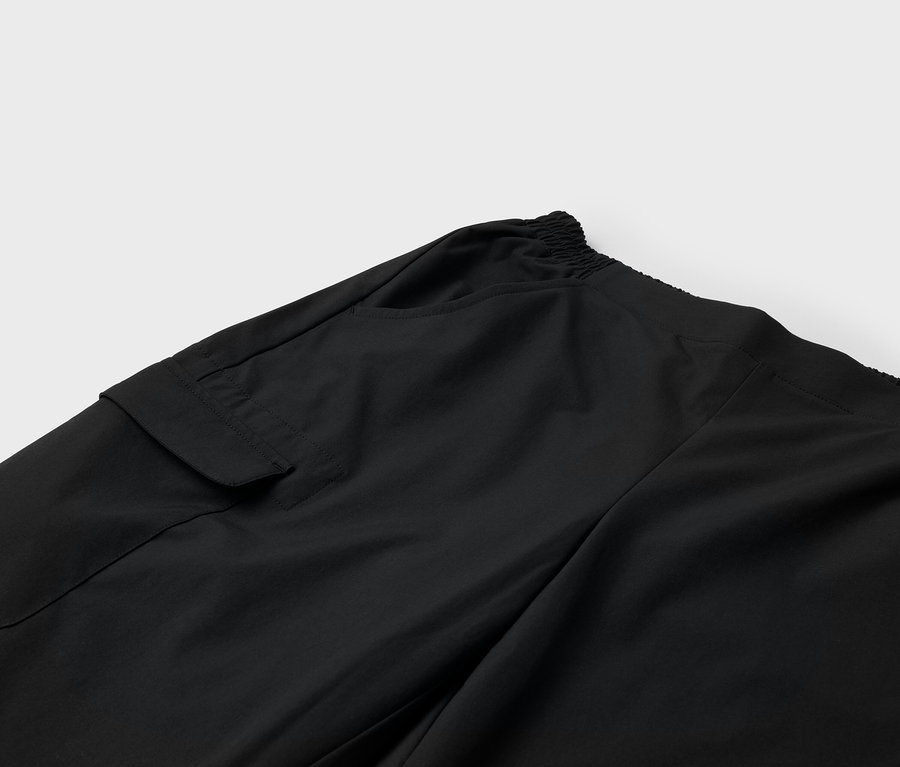 Detailaufnahme einer schwarzen Hose mit Tasche und Gummibund.