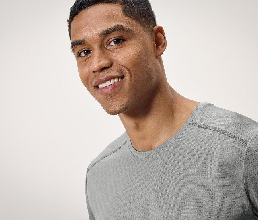 Porträt eines lächelnden Mannes in einem grauen T-Shirt.