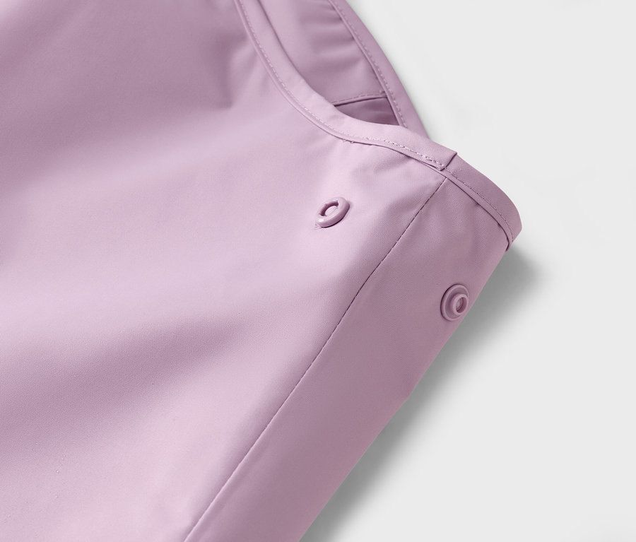 Nahaufnahme eines lila Regenmantels mit Druckknöpfen.