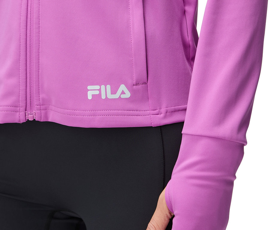Nahaufnahme einer Frau, die eine violette Fila-Jacke mit Daumenlöchern und schwarze Leggings trägt.