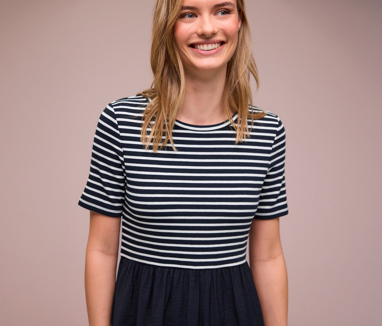 Frau lächelt und trägt ein blau-weiß gestreiftes Street One Kleid.