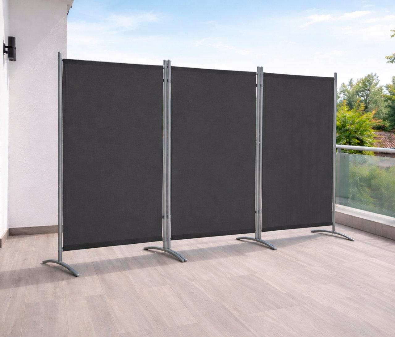 Aufnahme einer anthrazitfarbenen, 3-teiligen Leco Stellwand auf einem Balkon mit Holzboden.