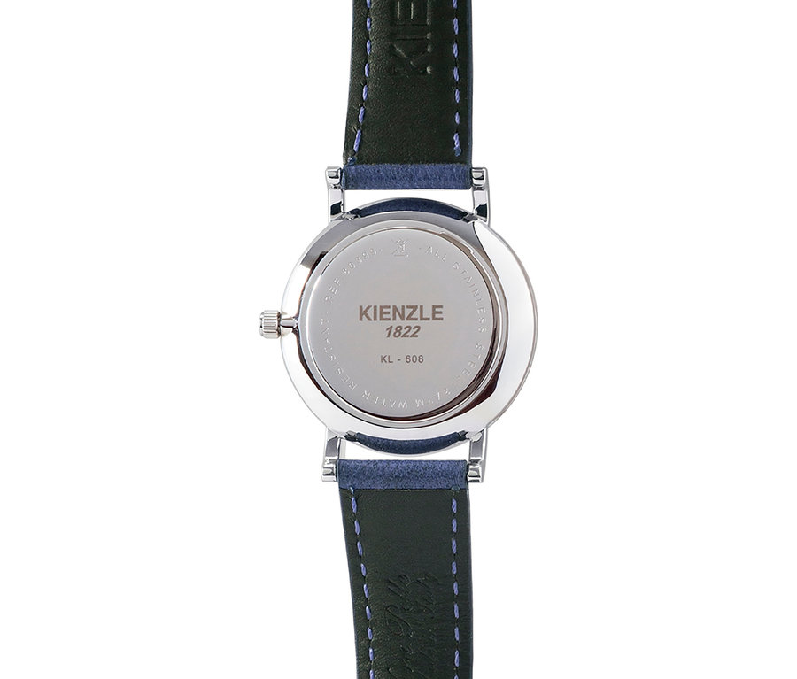 Rückseite einer silberfarbenen Uhr mit dunkelblauem Lederarmband und blauen Nähten. Auf dem Gehäuseboden steht "KIENZLE 1822" und "KL - 608".