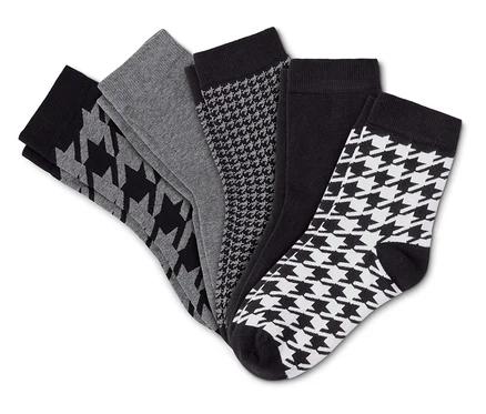 Fünf Socken in Schwarz, Grau und Weiß, teilweise mit Hahnentrittmuster, fächerförmig auf einem weißen Hintergrund ausgebreitet.