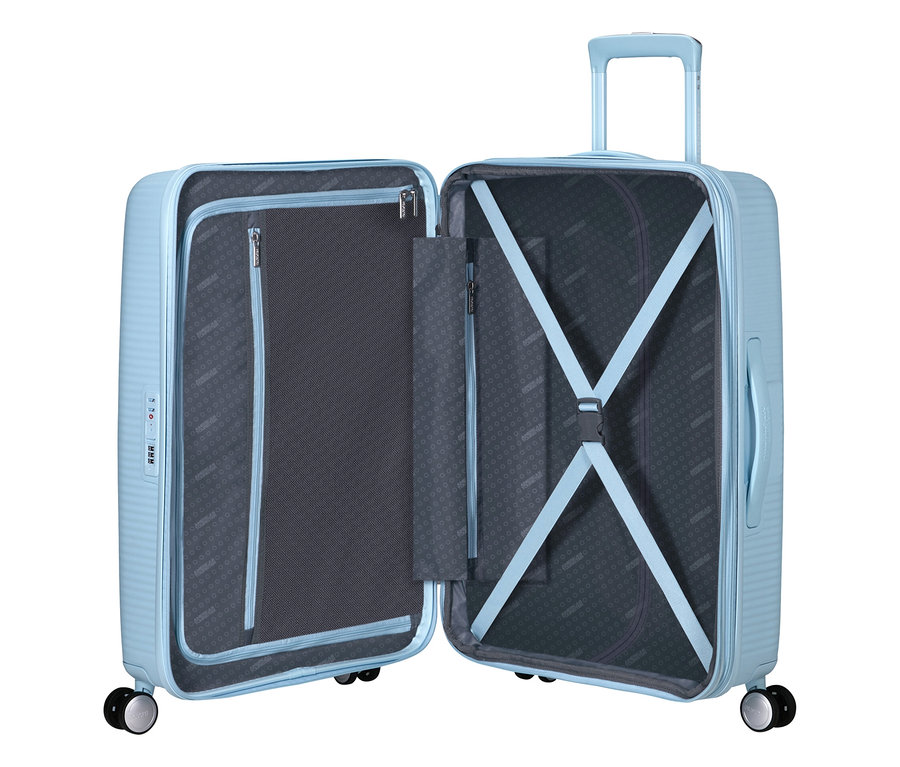Offener American Tourister Hartschalen-Koffer »Soundbox« Spinner, mittel, in Pastellblau, mit ausgefahrenem Griff, Reißverschlussfach und Kreuzspanngurten.