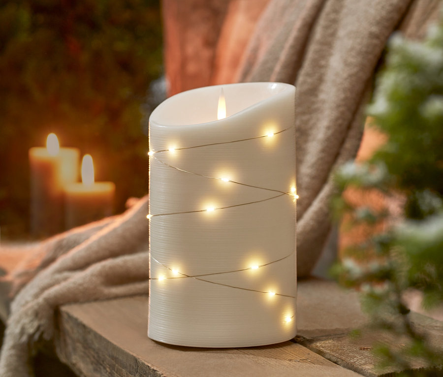 XL-Outdoor-LED-Echtwachskerze steht auf einer Holzbank.