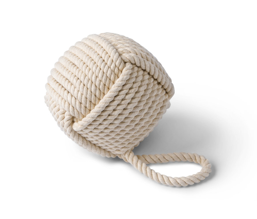 Ein beiger Türstopper in Kugelform aus Seil.