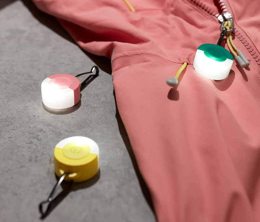 Eine pinke Jacke und drei LED-Anhänger.