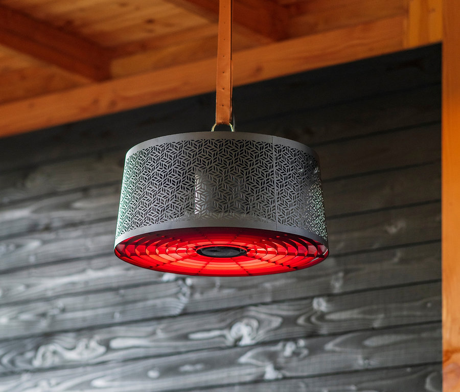Ein schwarzer Sunred® Smarter Hänge-Heizstrahler Artix Moderna Ultra Hanging Black 2.000 hängt über einem Tisch mit einer Weinflasche und einem Glas.