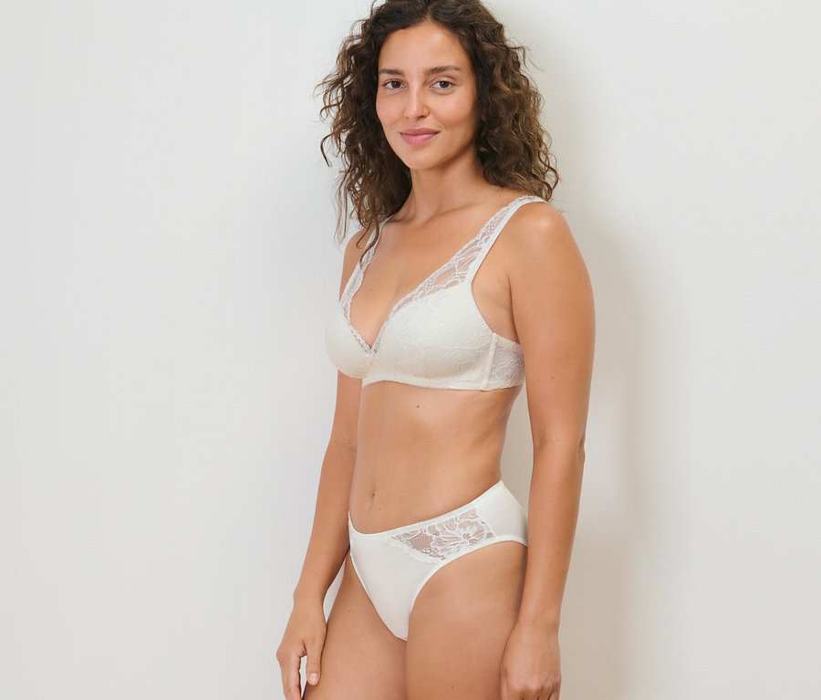 Frau posiert in einem BH und 2 Slips, creme.