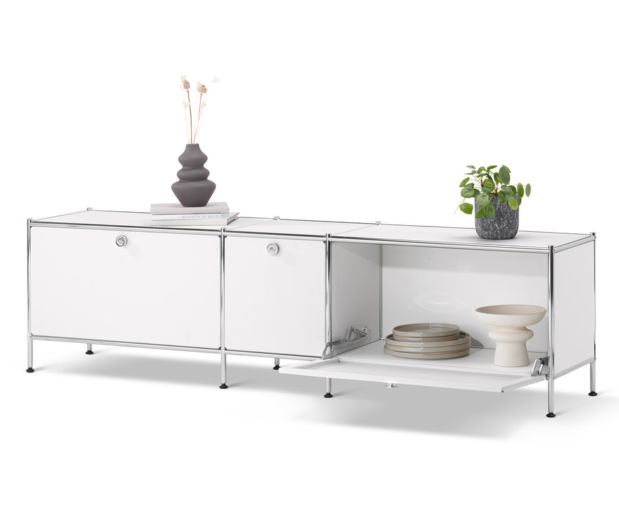 Weißes Lowboard »CN3« mit 3 Klappen. Auf dem Lowboard stehen eine Vase, ein Buch und eine Topfpflanze.