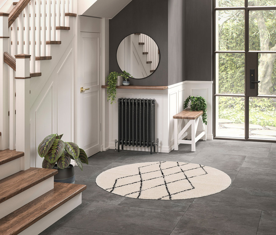 Eingangsbereich mit rundem Teppich »NOMAD Rhombus Line« und Treppe.
