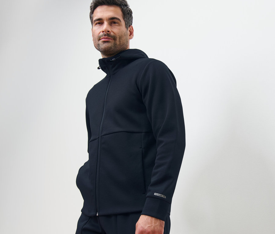 Mann posiert in dunkelblauer Funktionssweatjacke.