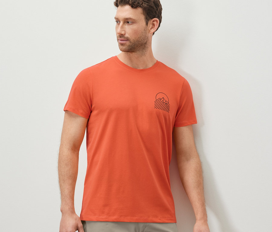 Mann trägt ein oranges T-Shirt mit Print.