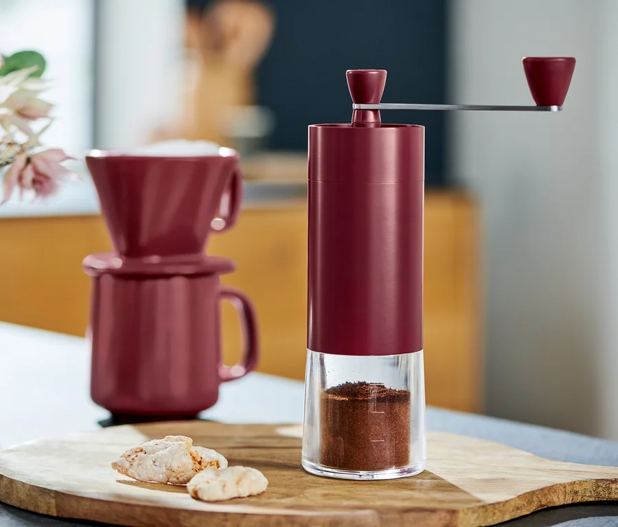 Detail einer Kaffeemühle manuell, berry, neben Tassen und Keksen.