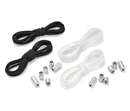 Zwei Paar elastische Schnürsenkel, ein Paar schwarz und ein Paar weiß, liegen nebeneinander mit Metallenden.