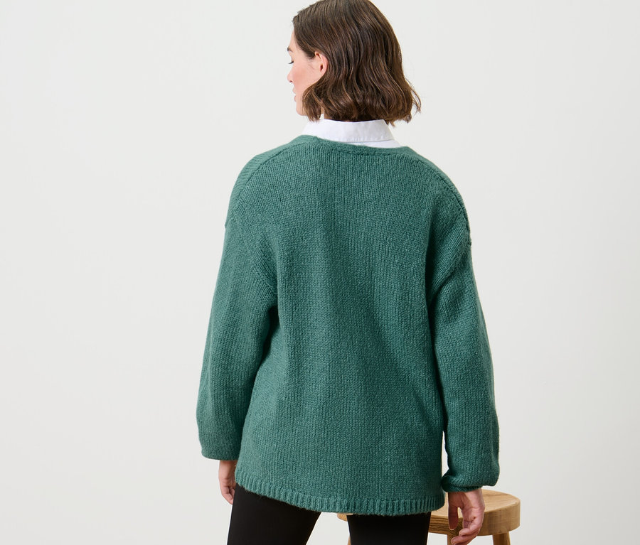 Frau trägt offenen Grobstrick-Cardigan.